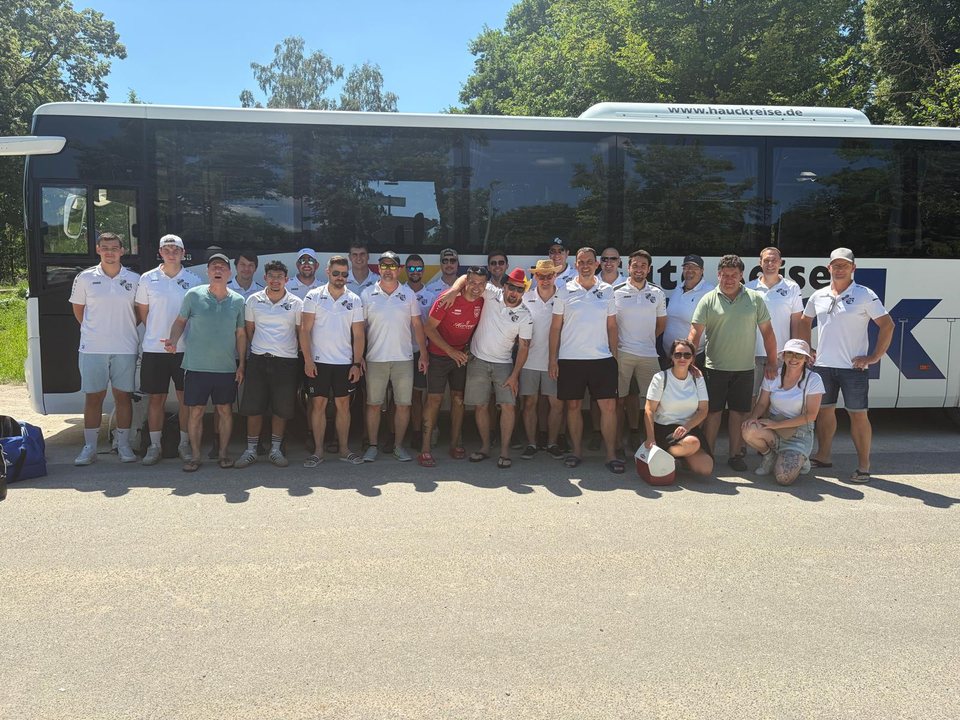 Gruppe der Alten Herren in weißen Shirts vor einem Reisebus