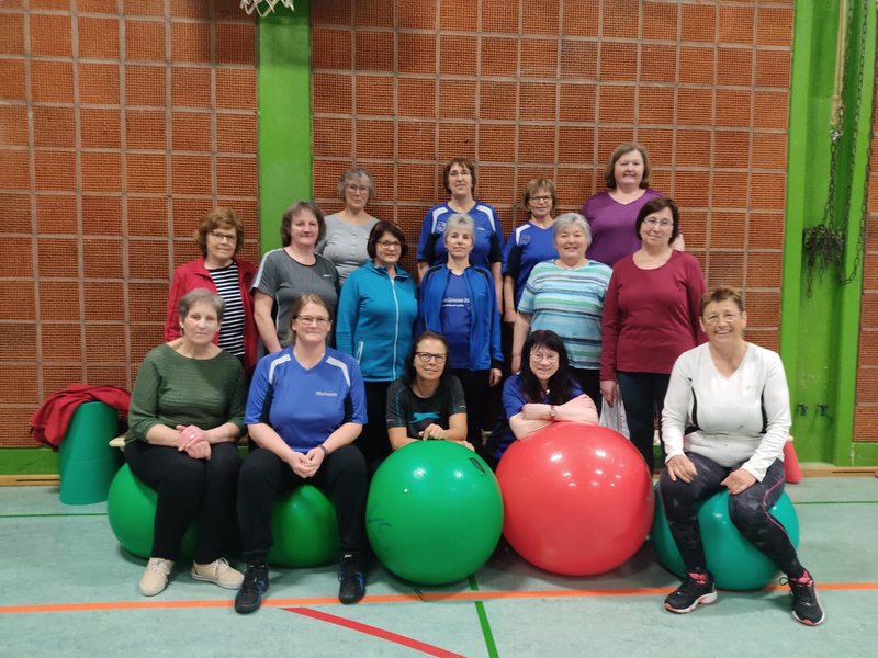 Die Damengymnastik-Gruppe mit großen Gymnastikbällen in der Sporthalle