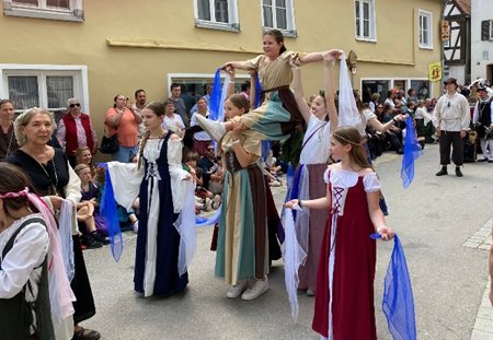Tänzerinnen in historischen Kostümen mit blauen Tüchern bei einem Auftritt in der Altstadt