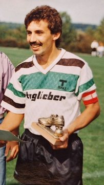 Erwin Taglieber im grün-weißen Trikot mit einer Trophäe