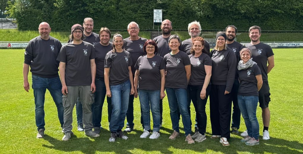 Gruppenfoto des Vereinsausschusses Historischer Markt in grauen Shirts auf dem Rasen