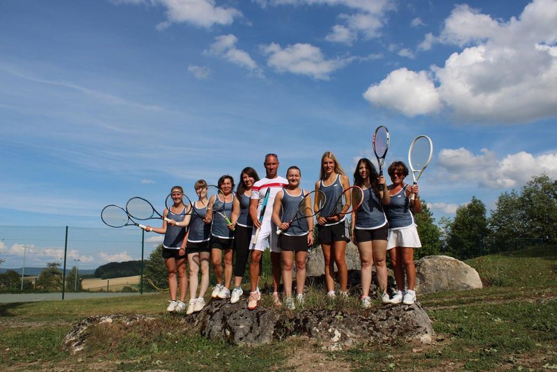 Tennisspielerinnen mit Schlägern posieren auf einem Felsen in der Landschaft